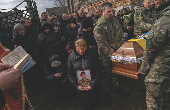 Rel­at­ives and friends mourn at the funeral of senior police ser­geant Roman Rushchy­shyn in the vil­lage of Soposhyn, out­skirts of Lviv, west­ern Ukraine, in March in Lviv. Rushchy­shyn, a mem­ber of the Lviv Spe­cial Police Patrol Bat­talion, was killed in the Luhansk region.
