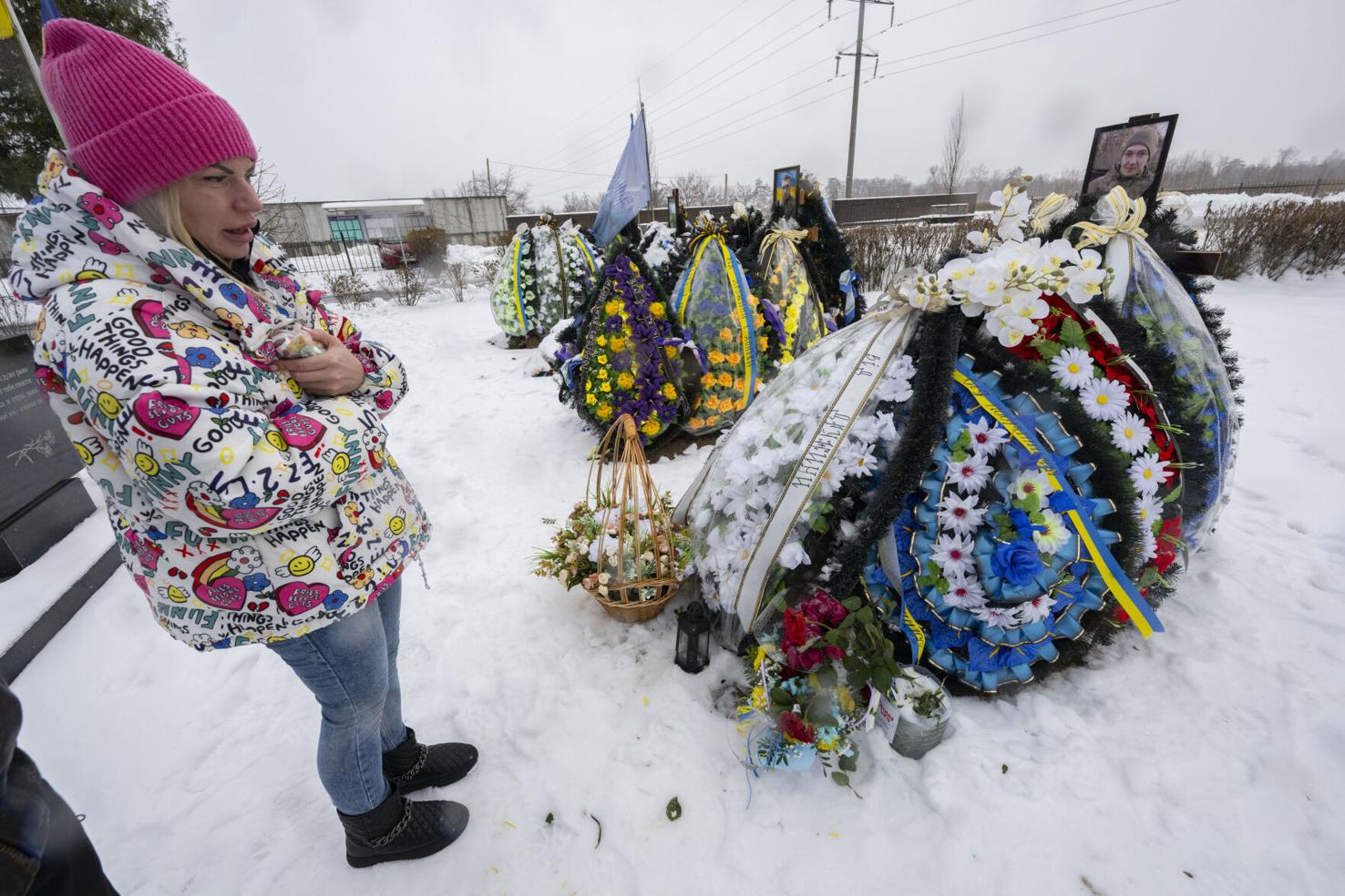 Yana Malyk visits a fresh grave of a Ukrainian soldier last month in Bucha, north of Kyiv. Russian soldiers killed dozens of civilians along Yablunska Street in the small town in the early days of war. The International Criminal Court is investigating the massacre as a war crime. Photo by Christian Murdock, The Gazette.